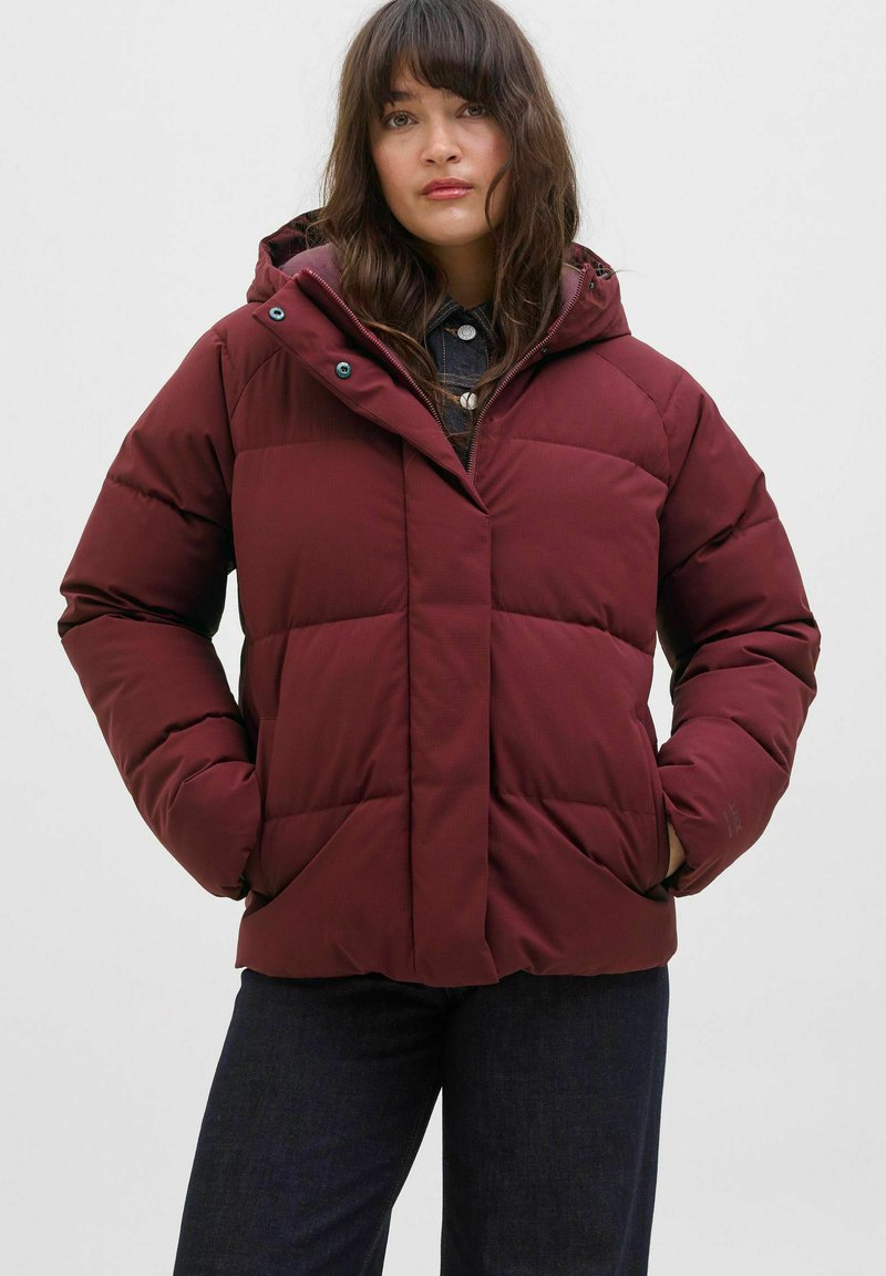 Burgundská péřová bunda s kapucí, prošívaný design, přední kapsy a zapínání na zip; obsahuje zelené kovové doplňky.