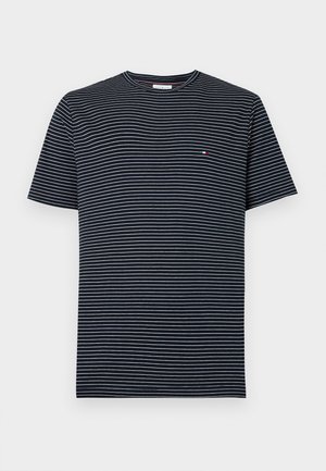 Marineblaues T-Shirt mit kurzen Ärmeln, dünnen weißen horizontalen Streifen und kleinem roten, weißen und blauen rechteckigem Logo auf der Brust.