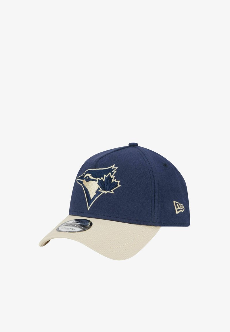 Navy blue cap with a beige brim, featuring an embroidered blue jay logo in gold on the front. Made from soft fabric, with structured design.