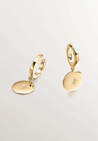 Pendientes de aro de oro con un charm circular que presenta un grabado de estrella. Acabado suave con una superficie pulida, que muestra una textura metálica brillante.