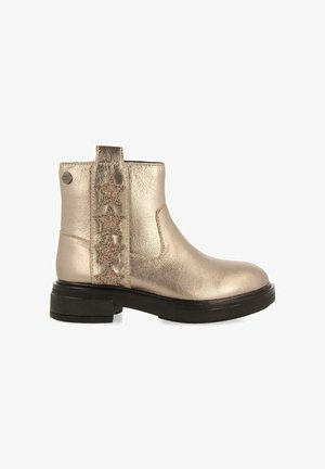 Stivaletto ankle in oro metallico con suola in gomma nera, con un dettaglio decorativo a forma di stella glitter sul lato e una linguetta sul retro.