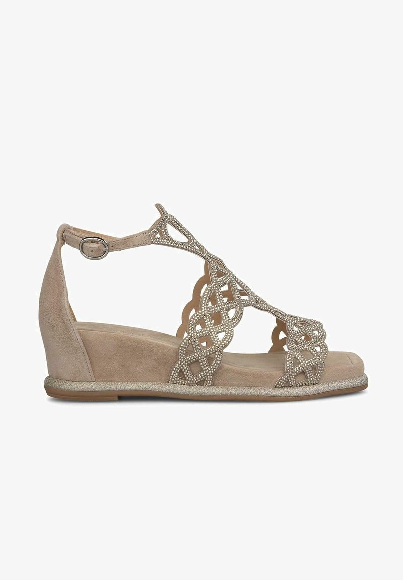 Sandalo a zeppa beige con tomaia in suede, design intagliato intricato e decorato con piccoli strass, completo di cinturino alla caviglia e suola piatta.