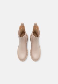 Vaaleanbeiget nilkkurit, jotka on valmistettu sileästä nahasta ja joissa on joustavat sivut, pyöreä kärki ja teksturoitu kumipohja.