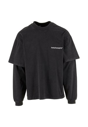 Sort oversized t-shirt lavet af bomuld. Har en rund halsudskæring, korte ærmer og teksten "Sunday Running Club" på venstre bryst.