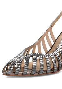 Chaussure ouverte à bout pointu en beige et argent, présentant un design géométrique avec des accents métalliques. Offre une apparence élégante.