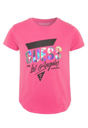 Camiseta de manga corta de color rosa brillante con logo holográfico "GUESS", formas geométricas negras y texto "Los Angeles California 1981" en el frente.