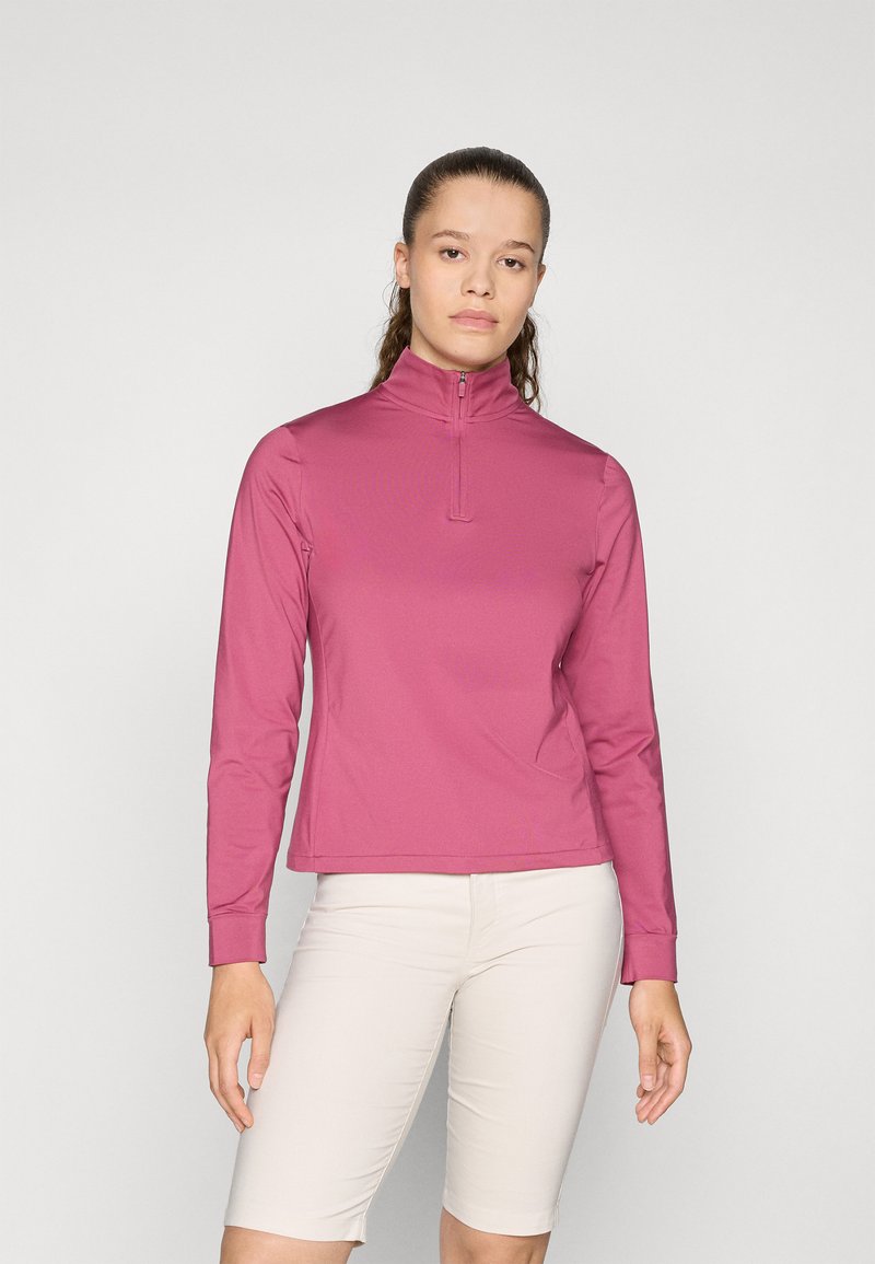 Lange mouwen, roze, tops met ritssluiting gemaakt van rekbare stof, met een getailleerd ontwerp en platte naden. G gedragen met lichtgekleurde shorts.