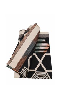 Coperta tessuta con audaci motivi geometrici in nero, bianco e tonalità terrose. Bordo rifinito con dettagli frangiati. Texture morbida.