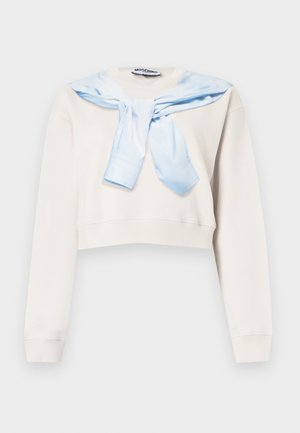 Sweat-shirt blanc court à manches longues avec une écharpe bleu clair drapée et nouée autour du cou.