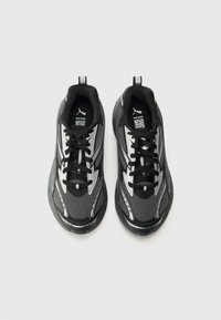 Schwarze und graue Sportschuhe mit einem Obermaterial aus Mesh, glatten metallischen Akzenten, runder Zehenpartie und schwarzen Schnürsenkeln mit einer Lasche an der Ferse.