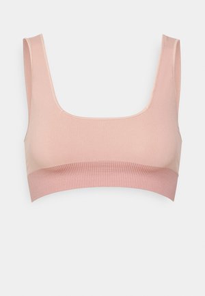 Lichtroze bralette gemaakt van zachte stof, met een vierkante halslijn en een geribbelde band aan de onderkant voor extra ondersteuning.