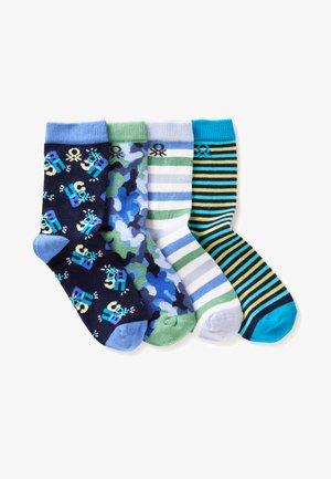 Vier paar kindersokken in blauw en groen met robot-, camouflage-, gestreepte en meerkleurige strepenpatronen, naast elkaar gelegd.