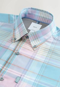 Camicia a quadri azzurro chiaro e pastello con colletto button-down, dotata di bottoni blu e di un piccolo etichetta del marchio sulla tasca del petto.