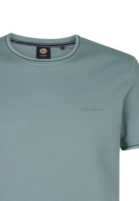 Ronde hals t-shirt in lichtblauw, gemaakt van textuurstof. Heeft een klein logo in lichte opdruk en gestreepte details op de halslijn.