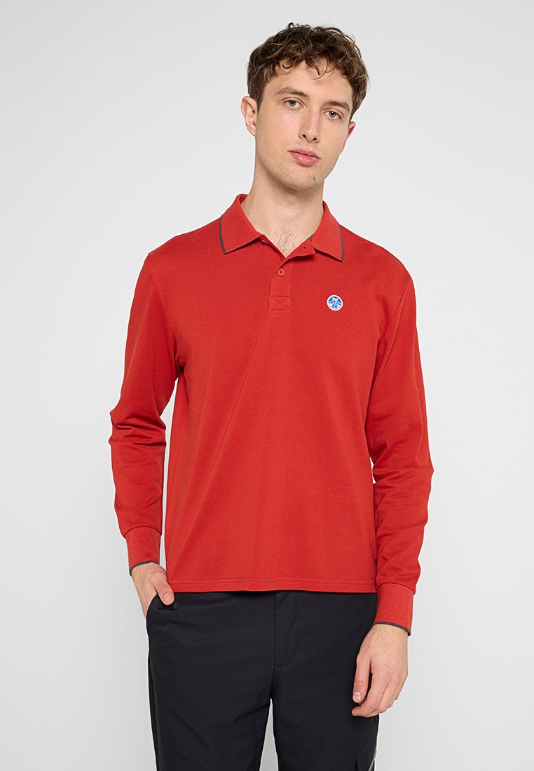 Camisa polo roja de manga larga hecha de algodón, con cuello tipo polo, tapeta de dos botones y un detalle de logo azul en el pecho.