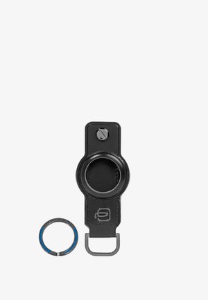 Llavero de cuero negro con tornillo y anillo de metal, diseñado para asegurar un dispositivo o accesorio pequeño y redondo.