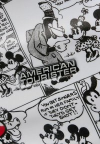 Valigia bianca con illustrazioni in nero di personaggi iconici e testo, con il logo argento "American Tourister" ben in vista.