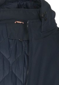 Primo piano di giacca trapuntata blu navy con cerniera, collo alto e coulisse regolabile per il cappuccio.