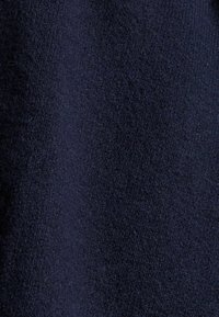 Tela de lana azul oscura con una textura fina, que muestra un tejido denso y suave con un ligero brillo. Sin patrones notables ni herrajes presentes.