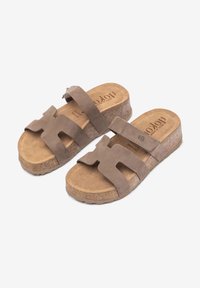 Las sandalias de ante marrón cuentan con dos correas anchas y una suela de corcho. Suave textura con una plantilla contorneada para mayor comodidad. Sin tacón.