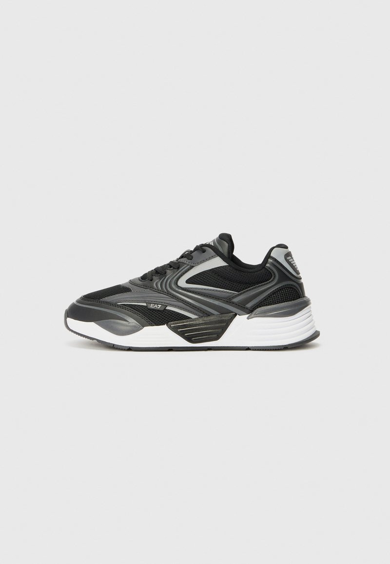 Black athletic shoe with mesh and synthetic overlays. Features a thick white midsole and gray accents, designed for comfort and stability.
