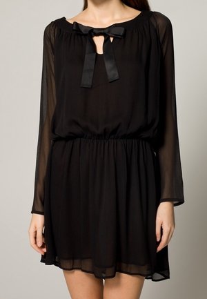 Zwarte chiffonjurk met lange, doorschijnende mouwen, een ronde halslijn en een strikdetail aan de voorkant. Elastische taille en een zwierende rok.