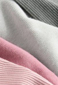 Neljä päällekkäistä kangaspalaa: vaaleanpunainen, vaaleanharmaa, tummanharmaa ja ribbitekstuuri. Pehmeä, neulottu materiaali, jolla on sileä pinta.