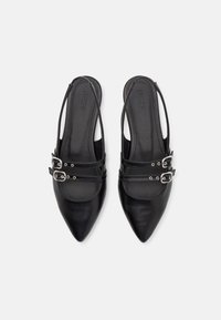 Schwarze Leder-Slingback-Schuhe mit spitzen Zehen, ausgestattet mit zwei verstellbaren silbernen Schnallen und einer glatten matten Textur.