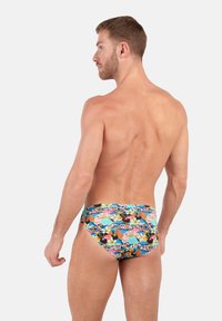 Floral swim briefs featuring a vibrant pattern with pink, blue, and black flowers on a multicolored background. Made from lightweight material.