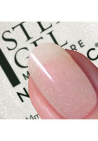 Negl med en myk rosa base og subtil, fin shimmer som fremviser en glatt og blank overflate. Bakgrunnen inneholder merkevaretekst.