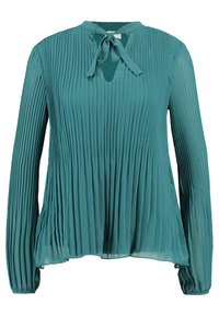 Blusa lunga a maniche lunghe di colore verde acqua, con scollo rotondo e dettaglio con fiocco, caratterizzata da una vestibilità ampia e una trama trasparente.
