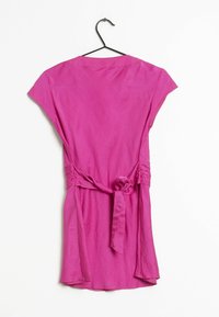 Short-sleeve, fuchsia dress with a tie waist detail, smooth texture, and a relaxed fit, hanging on a black hook against a white background.