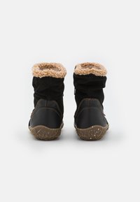 Zwarte enkellaarzen met een zachte tan kleur bontmanchet, van suède en synthetisch materiaal, met een gestructureerde zool met een robuust patroon en decoratieve stiksels.