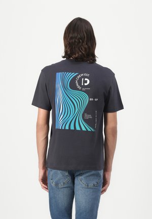 Marine bomull t-skjorte med et blått og teal bølgemønster på baksiden, med et grafisk motiv og tekst som indikerer "DENIM CREW EST. 20-07."