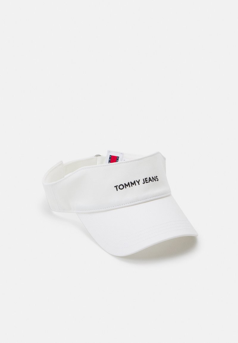 White visor cap featuring a curved brim, adjustable strap, and embroidered "TOMMY JEANS" text on the front. Smooth fabric texture.