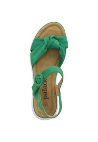 Sandalo in suede verde con design anteriore annodato, soletta imbottita marrone e accentuazione con fibbia circolare sulla cinghia.