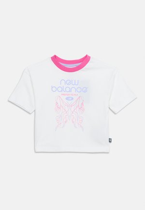 Hvit t-skjorte med korte ermer og rosa krage, med teksten "new balance", slagordet "prefer to fly" og grafikk av en joggesko med vinger i lys lilla og rosa.