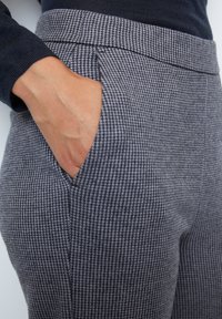 Grijze broek met pied-de-poule patroon, voorzien van een slim fit, zijzakken en een tailleband. Glad textiel met een subtiele textuur.