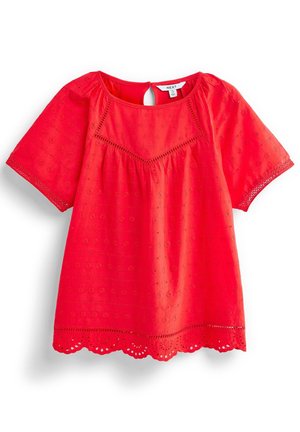 Blouse rouge vif à manches courtes avec détails floraux en œillet, ourlet festonné, encolure ronde et fermeture avec bouton à l'arrière.