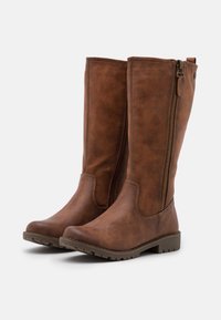 Bottes marron montant jusqu'aux genoux en similicuir texturé, avec des fermetures éclair latérales et une semelle en caoutchouc à motifs antidérapants. Design de tige lisse.