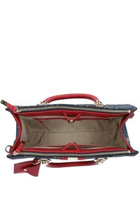 Denim-Handtasche mit roten Lederakzenten, Reißverschlussverschluss, doppelten Griffen und einem geräumigen beige Innenraum mit Organisationsfächern und Hardware.