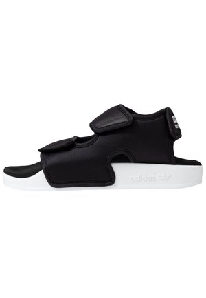Sort sandal med åben tå med justerbare remme og hvid sål, med polstret overdel og Adidas-logo præget på siden af sålen.