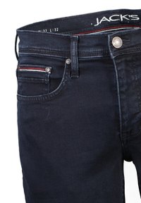 Jeans de mezclilla azul oscuro con un corte slim, que cuentan con un bolsillo frontal, acentos de costura roja y blanca, y un cierre de botón metálico.