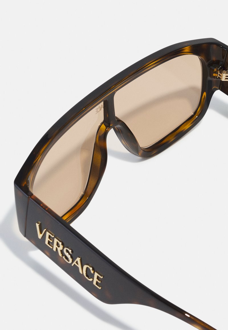 schildpad-achtige kunststof zonnebril met bruine lenzen, met een gedurfde, rechthoekige vorm en een verguld "VERSACE" logo dat op de poot is gedrukt.