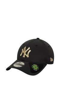 Gorra de béisbol negra con el logotipo en relieve de los New York Yankees en beige en la parte frontal, que cuenta con una tela texturizada y una correa ajustable en la parte posterior.