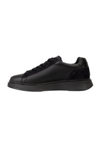 Sneakeruri negre cu talpă joasă, din piele texturată, cu accente de suede, vârf rotund, șireturi și talpă groasă din cauciuc, văzute din lateral.