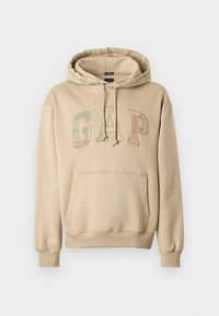 Beżowa bluza z kapturem z kieszenią kangurką. Posiada wielokolorowy, wzorzysty kaptur i logo „GAP” w stylizowanych literach. Wykonana z miękkiego materiału.