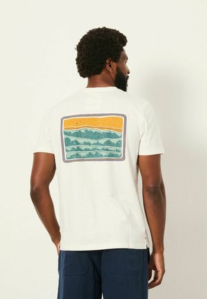 Weißes Baumwoll-T-Shirt mit kurzen Ärmeln, auf der Rückseite mit einem bunten Gebirgsmotiv in Orange, Türkis und Blau.