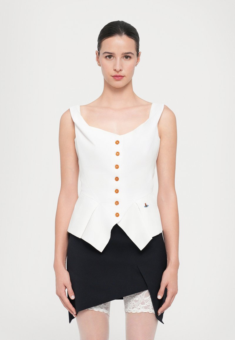 Hvid peplum top med orange knapper og en lille blå accent; har en firkantet udskæring og brede stropper. Bæres med en sort nederdel.