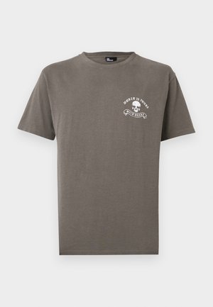 T-shirt marrone a maniche corte con collo a giro e piccolo teschio bianco con le scritte "WORLD IS YOURS" e "WILD HEART" sul petto a sinistra.